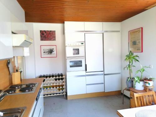 a kitchen with white cabinets and a refrigerator at Dimai House 1970s in Hohenems