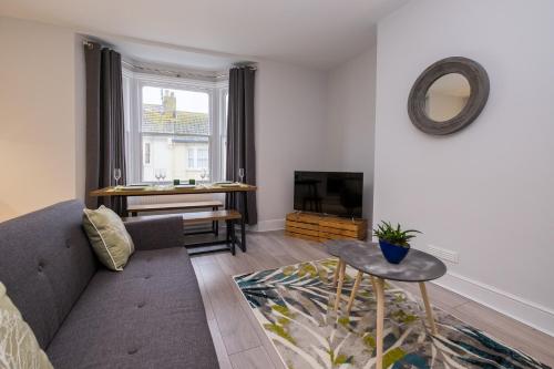 a living room with a couch and a tv at Beautiful Central Apartment in Brighton & Hove