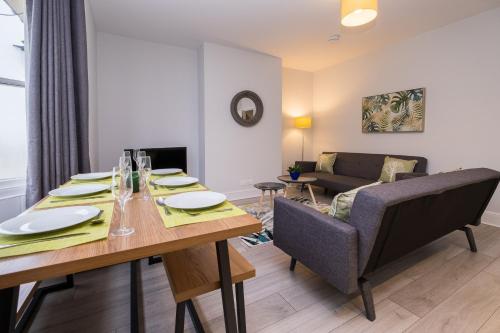 a dining room with a table and a couch at Beautiful Central Apartment in Brighton & Hove