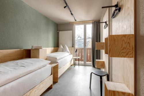 a hotel room with two beds and a window at Belmont- Apartment Haus in Arosa