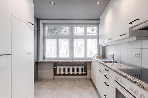 a kitchen with a large window and a radiator at Belmont- Apartment Haus in Arosa