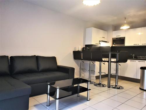 uma sala de estar com um sofá preto e uma cozinha em Palazzio 2, by Welcome to Cannes em Cannes
