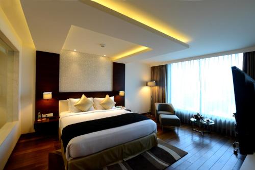 a hotel room with a large bed and a window at Howard Johnson By Wyndham, Hebbal, Bengaluru in Bengaluru