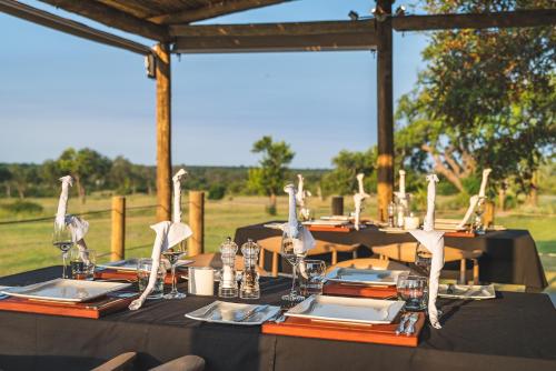 a set of tables with black tablecloths and napkins at Nkorho Bush Lodge in Sabi Sand Game Reserve