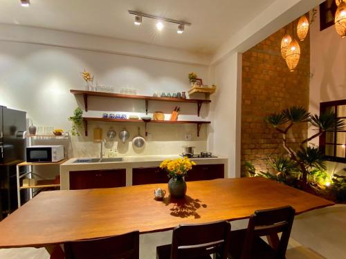 a kitchen with a wooden table in a room at Okra Hoian in Hoi An