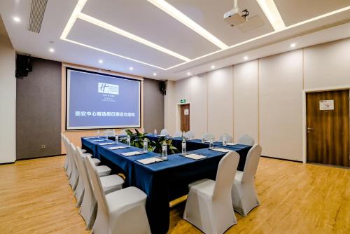 a conference room with a long table and white chairs at Holiday Inn Express Taian City Center by IHG in Tai'an