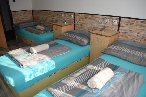 a room with three beds with towels on them at Ubytování u Šveců u Adršpachu in Jívka