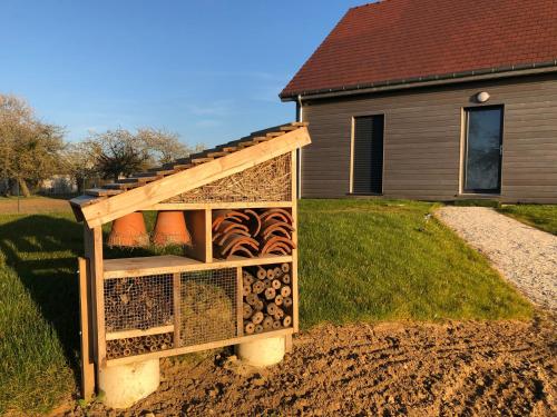 a chicken coop with a wooden roof on top at LES BOIS DE CHAMPAGNE NORDIQUE in Magnant