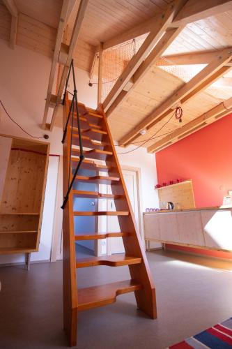 a wooden staircase in a room with a loft at tvrz KRASSA in Osečná