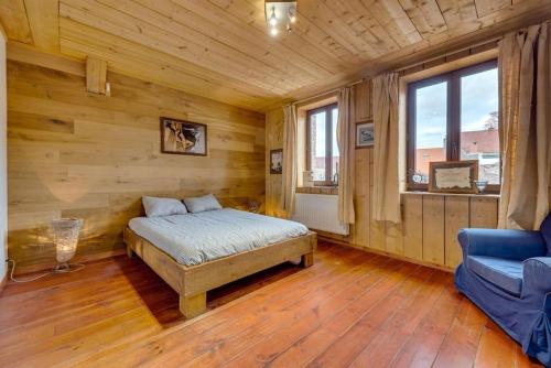 een slaapkamer met een bed en een bank in een kamer bij maison familiale près de bruxelles et paridaisia in Enghien