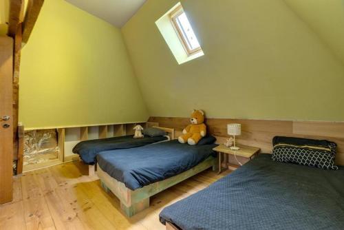 a bedroom with two beds with a teddy bear sitting on top at maison familiale près de bruxelles et paridaisia in Enghien
