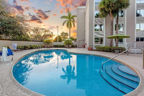 a swimming pool in a hotel with a sunset at La Quinta by Wyndham Coral Springs South in Coral Springs