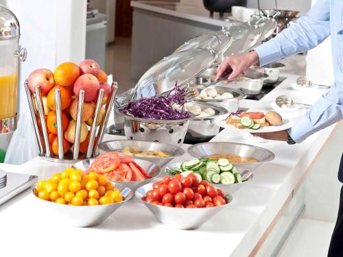 a buffet with bowls of fruits and vegetables on a counter at ibis Paris Canal Saint Martin in Paris