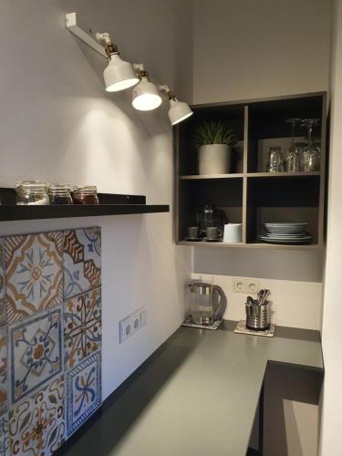 uma cozinha com um balcão com uma parede de azulejos em Valet Apartment em Mārupe