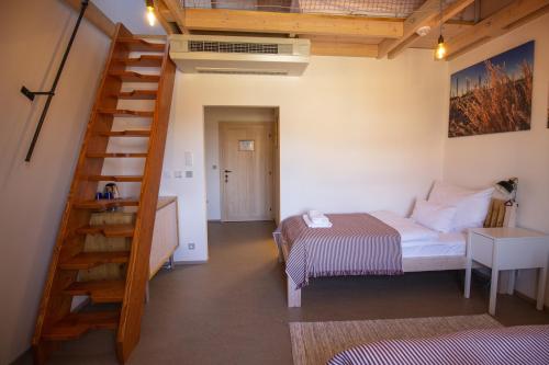 a bedroom with a bed and a staircase in a room at tvrz KRASSA in Osečná