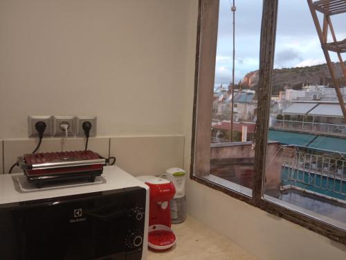 kuchnia z oknem z widokiem na budynek w obiekcie Roof Top Studio in Koukaki w Atenach