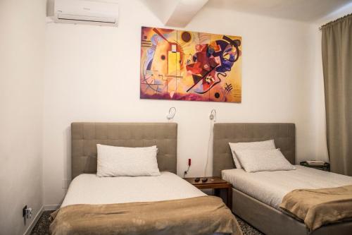2 letti in una camera con un dipinto sul muro di Rho-Fiera - Appartamento in antica cascina a Pero