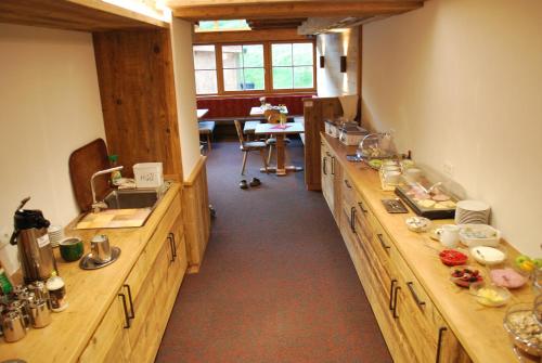 a large kitchen with wooden counters and a sink at Alpengasthof Götschenalm in Bischofswiesen