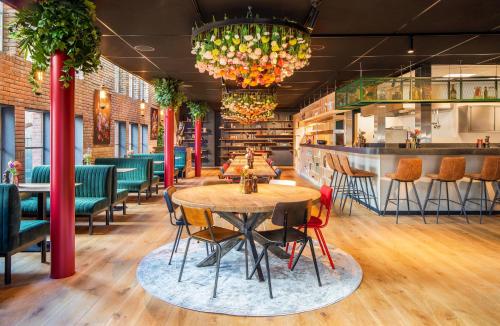 a restaurant with tables and chairs and a bar at Bunk Hotel Amsterdam in Amsterdam