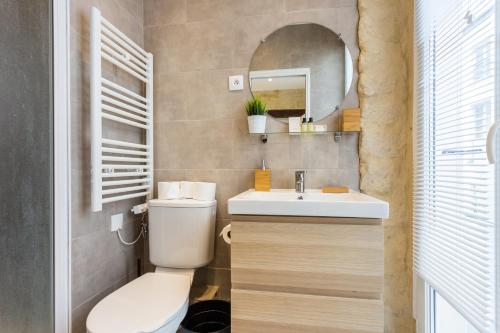 une salle de bain avec toilettes, lavabo et miroir dans l'établissement CMG Réaumur Sébastopol - Tracy 3, à Paris
