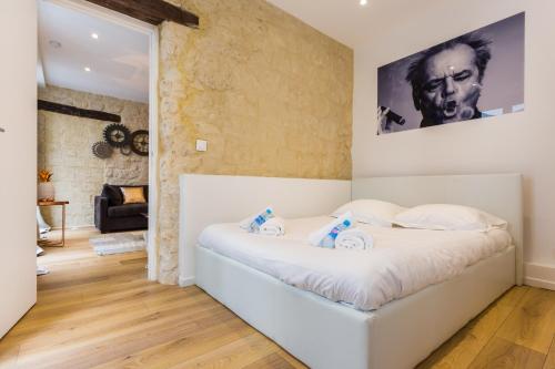 - une chambre avec un lit blanc et une affiche murale dans l'établissement CMG Réaumur Sébastopol - Tracy 3, à Paris