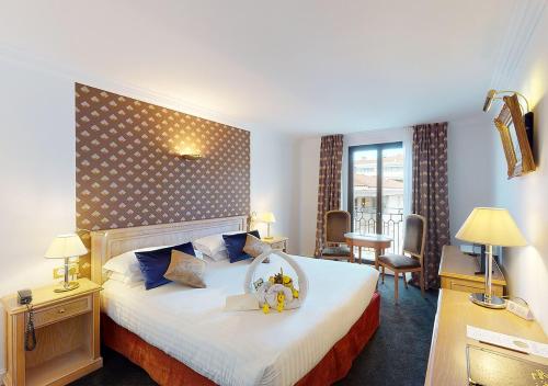 um quarto de hotel com uma cama grande e uma grande cabeceira em Sun Riviera Hotel em Cannes