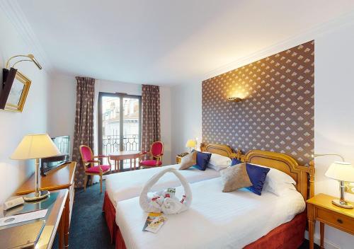 une chambre d'hôtel avec un lit, une table et des chaises dans l'établissement Sun Riviera Hotel, à Cannes