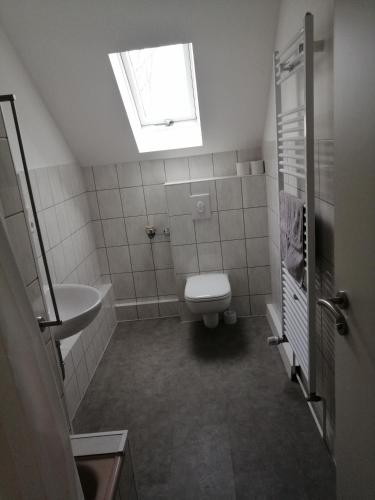 a bathroom with a toilet and a sink and a window at Kölsche Wohnung 1C in Cologne
