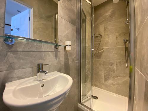 a bathroom with a sink and a glass shower at Belvedere Hotel in London