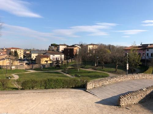 a park with buildings and a stone wall and a street at La casa della Ada in Castelnuovo del Garda