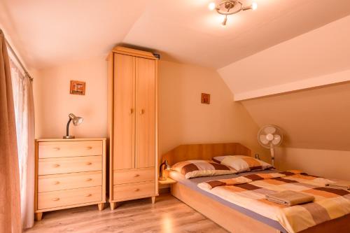 een slaapkamer met een bed en een dressoir bij Chatka Elegant in Bešeňová