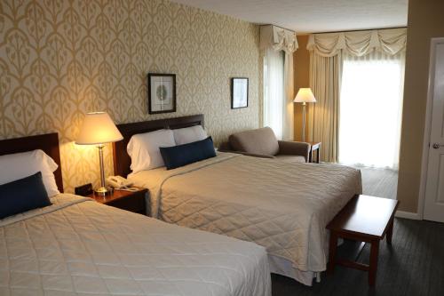 Habitación de hotel con 2 camas y ventana en The Village Inn, en Harrisonburg