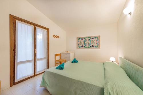 een slaapkamer met een groen bed en een groot raam bij Ambra White in Li Valcaggi