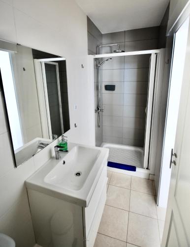a white bathroom with a sink and a shower at Marine Lovers - Jacuzzi Fuerteventura in Gran Tarajal