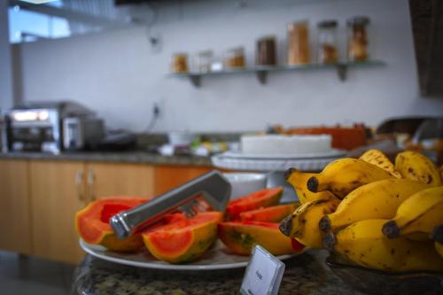 a plate of fruit on a table in a kitchen at Pioneiro Hotel in Teixeira de Freitas