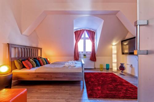 1 dormitorio con 1 cama con alfombra roja y ventana en Luxury Paulay street Apartment, en Budapest