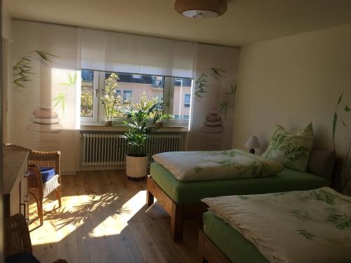 a bedroom with two beds and a window at Stadtferienwohnung in Müllheim