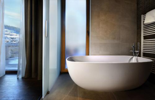 a large white tub in a bathroom with a window at Chalet Norvinga Jasná in Demanovska Dolina