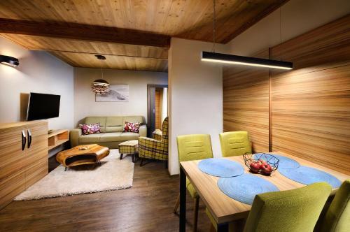 a dining room with a table and a couch at Chalet Norvinga Jasná in Demanovska Dolina