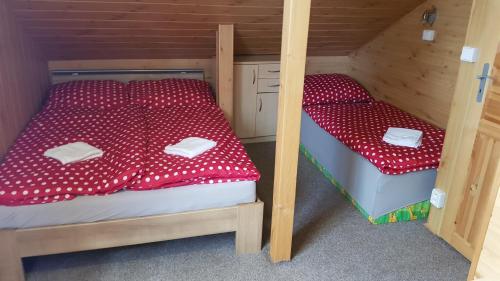 2 łóżka piętrowe z czerwoną pościelą w pokoju w obiekcie Chaloupka v pohodě w mieście Jetřichovice