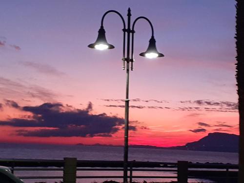 ein Straßenlicht mit Sonnenuntergang im Hintergrund in der Unterkunft Azzurra casa vacanza in Ventimiglia