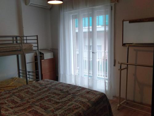 ein Schlafzimmer mit einem Bett und einem großen Fenster in der Unterkunft Azzurra casa vacanza in Ventimiglia