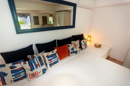 a mirror on a wall above a couch with pillows at Studio Lotte - Ocean Front in Las Galeras