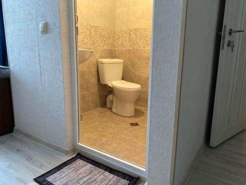 a small bathroom with a toilet in a doorway at Golden Gate in Akhaltsikhe