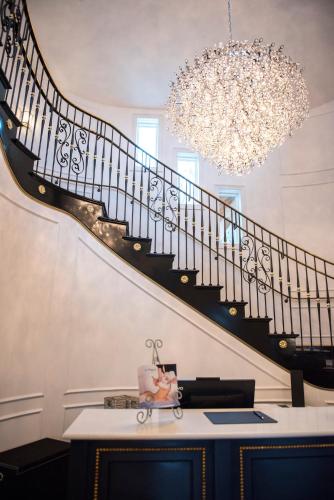 a staircase in a house with a desk and a chandelier at Mirbeau Inn & Spa, Rhinebeck in Rhinebeck