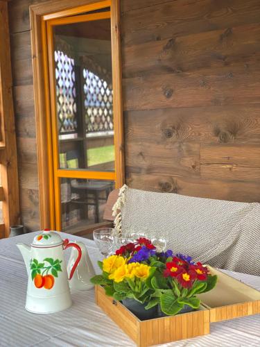 a wooden box with a bouquet of flowers on a table at INNA BAJKA in Nowy Berezów