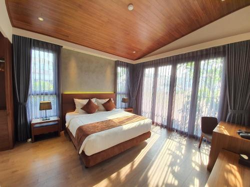 een slaapkamer met een bed in een kamer met ramen bij Orchid Boutique Hotel & Apartment in Ho Chi Minh-stad