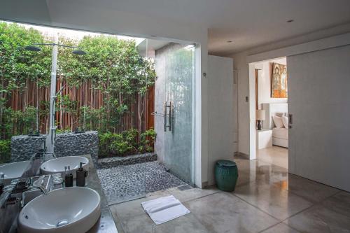łazienka z 2 umywalkami i prysznicem w obiekcie CassaMia Bali - Spacious Luxury 5 Bedroom Villa, 100m from Beach with Butler w mieście Jimbaran