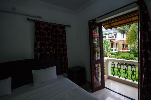 1 dormitorio con 1 cama y ventana con balcón en Villa 15 White Square Nirvana, Guirim, Parra, en Parra