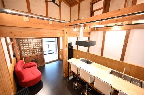 a room with a table and chairs and a red chair at Manabi-stay Takayama in Takayama